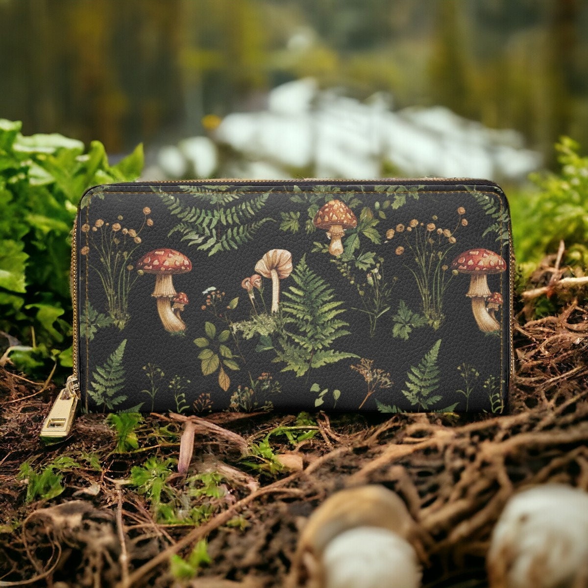 Vegan leather wallet with a mushroom and fern print, featuring red and white toadstool mushrooms and ferns, set against a natural forest floor backdrop.